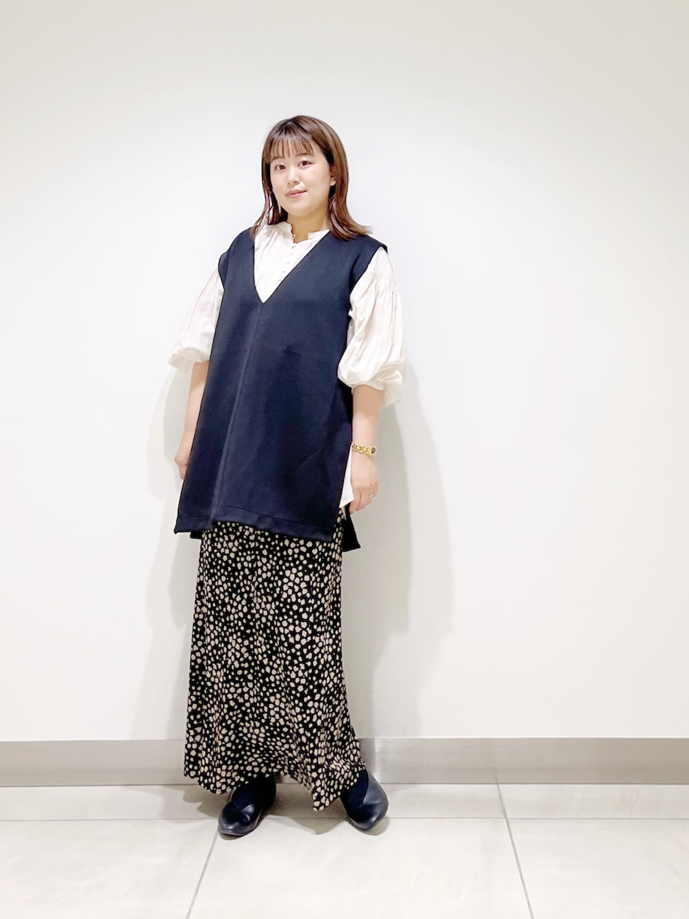 ブラック系のベスト、ホワイト系のシャツ/ブラウス、ブラック系のスカートを着用したレディースの夏コーディネートの3枚目の写真