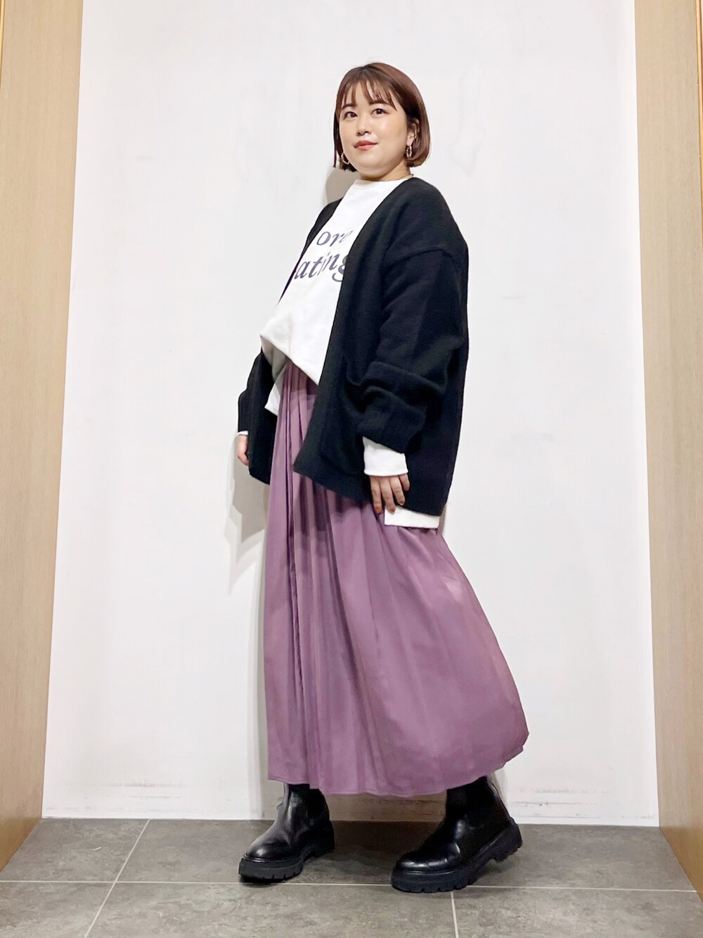 ホワイト系のTシャツ/カットソー、ブラック系のカーディガン/ボレロ、パープル系のスカートを着用したレディースの秋コーディネートの4枚目の写真