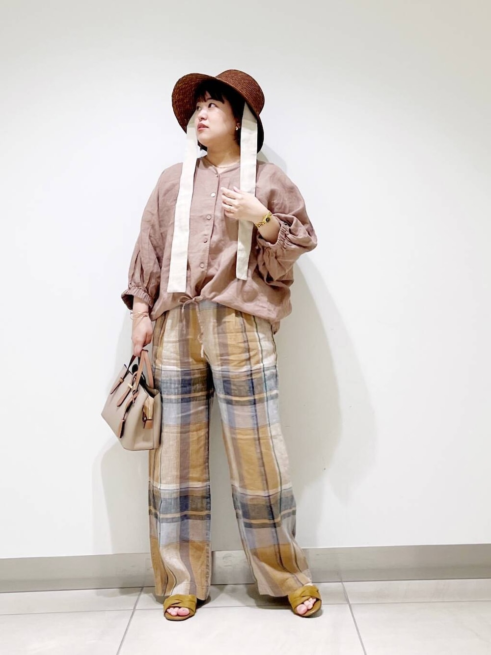 ベージュ系のハンドバッグ、イエロー系のその他パンツ、イエロー系のサンダルを着用したレディースの春コーディネートの2枚目の写真