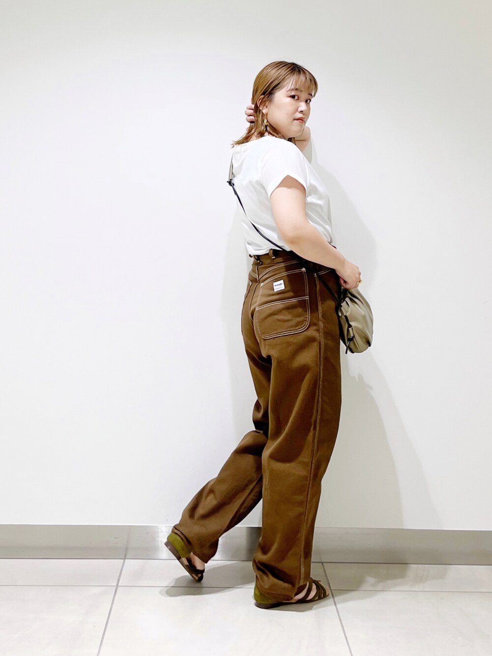 ホワイト系のTシャツ/カットソー、ブラウン系のその他パンツ、ベージュ系のショルダーバッグを着用したレディースの夏コーディネートの3枚目の写真