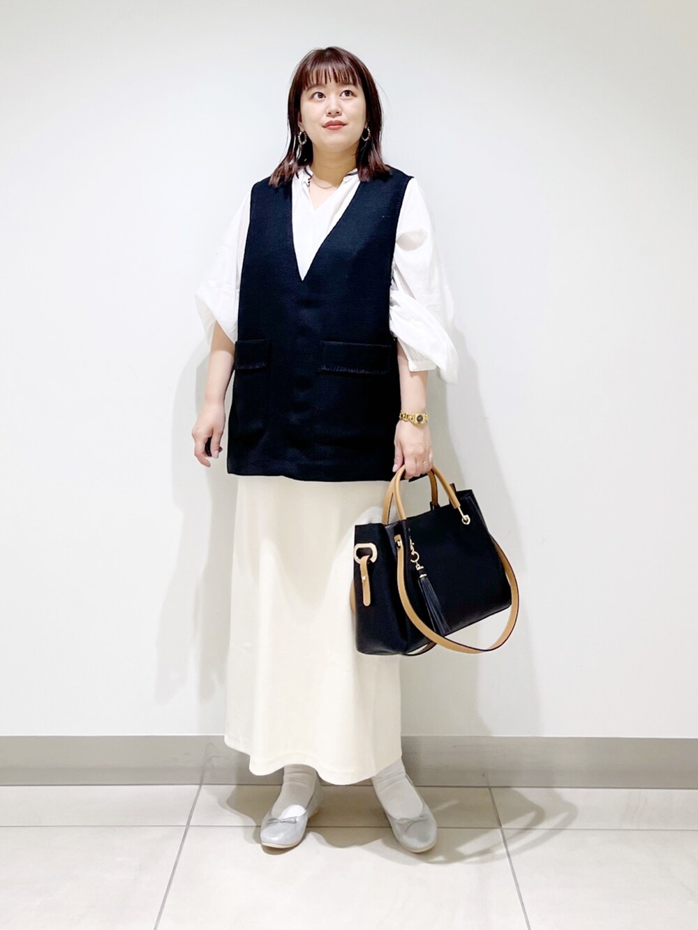 ブラック系のトップス、ホワイト系のシャツ/ブラウス、その他のスカートを着用したレディースの秋コーディネートの9枚目の写真