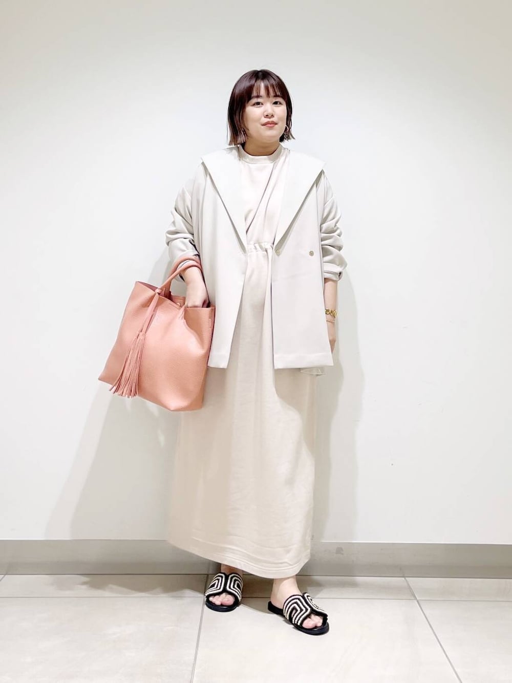 ピンク系のトートバッグ、ベージュ系のその他アウター、ベージュ系のワンピースを着用したレディースの春コーディネートの8枚目の写真