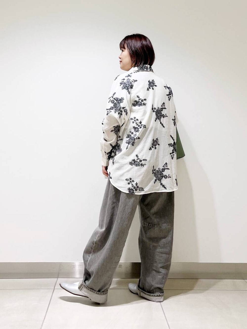 グリーン系のデニムパンツ、グリーン系のトートバッグ、シルバー系のパンプスを着用したレディースの春コーディネートの6枚目の写真