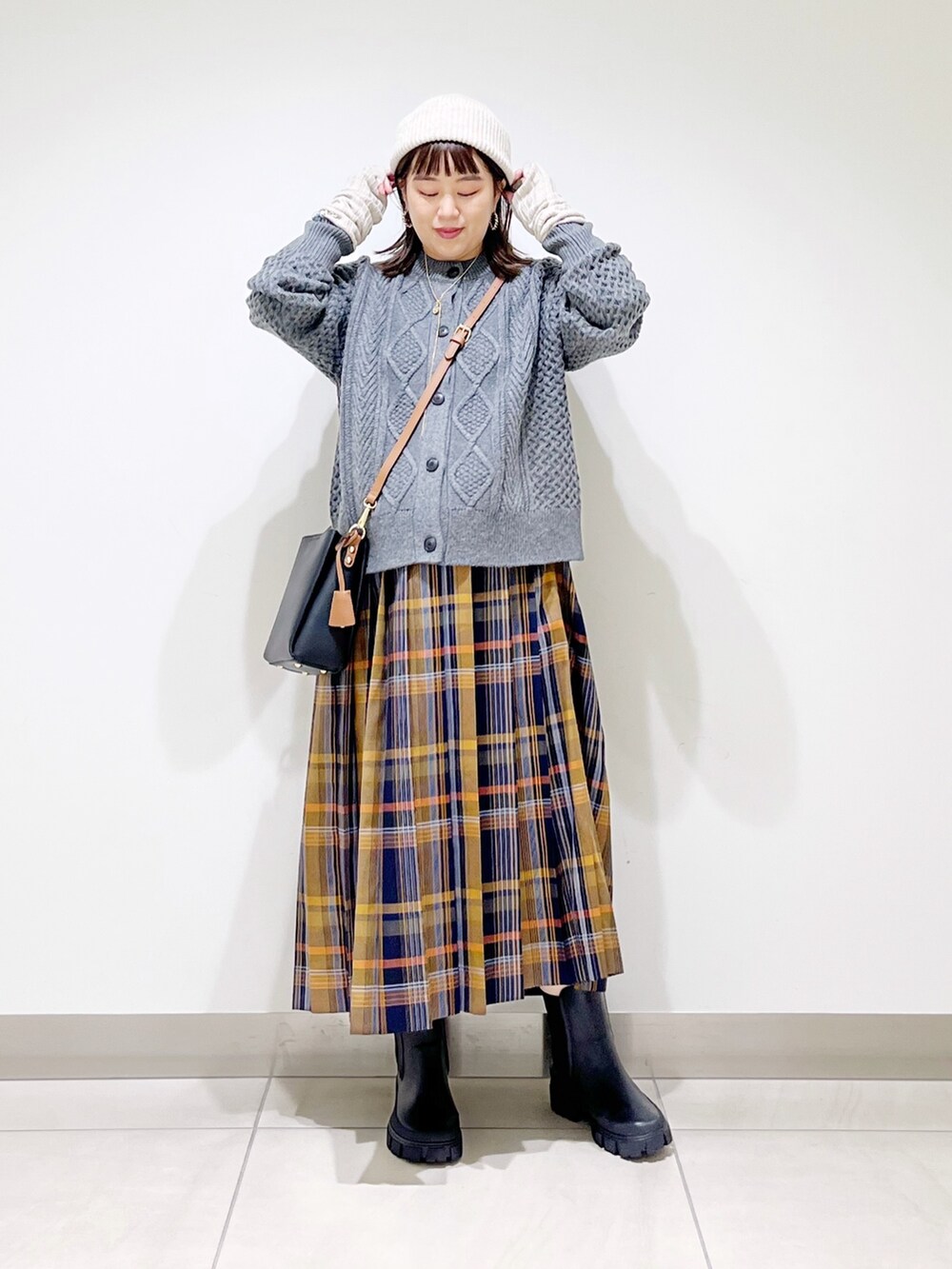 グレー系のカーディガン/ボレロ、ブルー系のスカート、ブラック系のショルダーバッグを着用したレディースの冬コーディネートの6枚目の写真