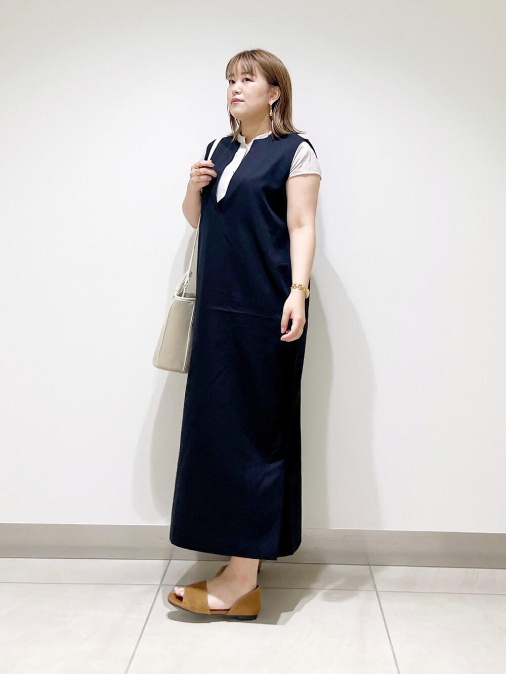 ブラック系のワンピース、ベージュ系のショルダーバッグ、イエロー系のサンダルを着用したレディースの夏コーディネートの4枚目の写真