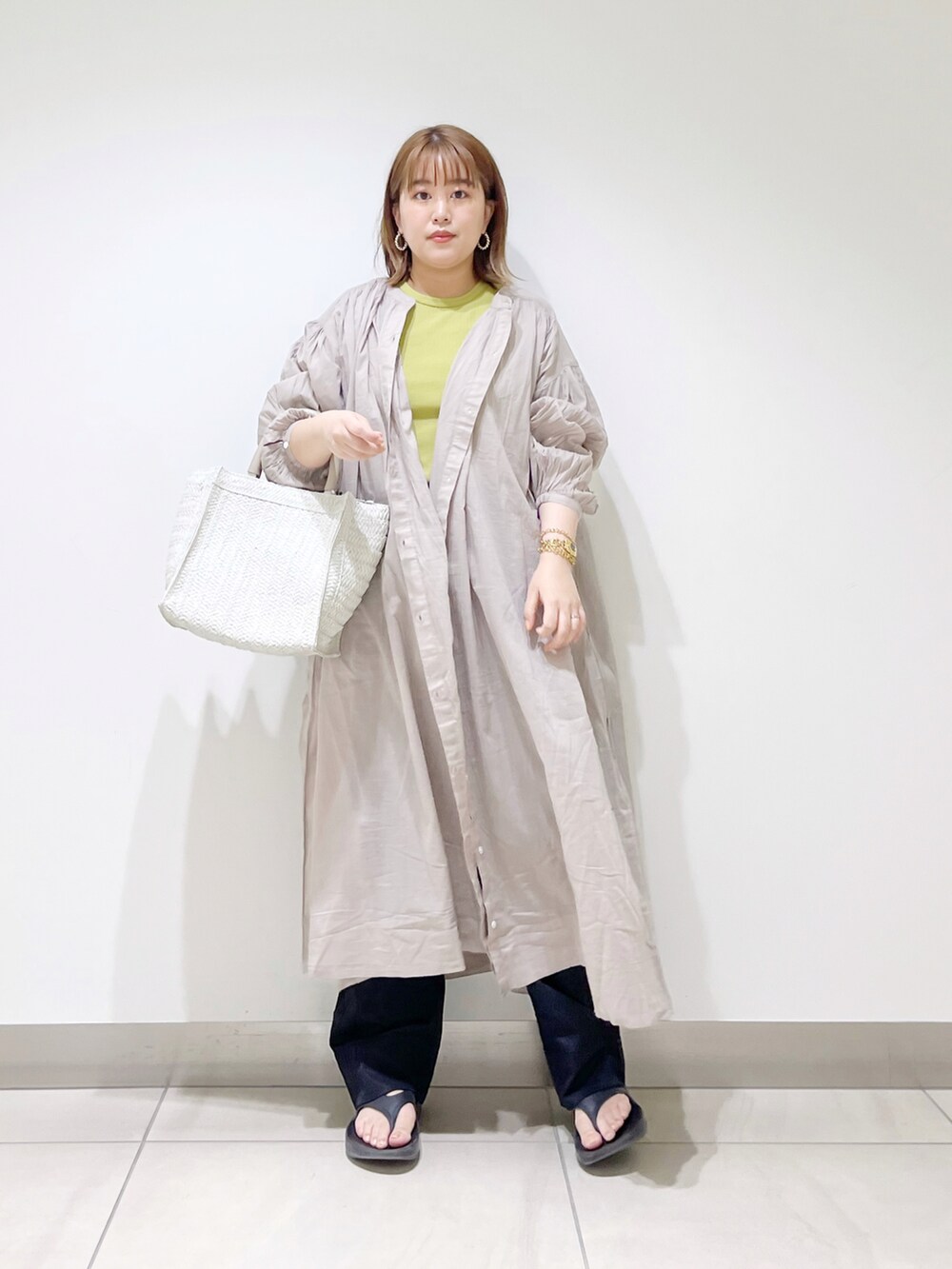 グレー系のワンピース、ホワイト系のトートバッグ、グリーン系のTシャツ/カットソーを着用したレディースの春コーディネートの3枚目の写真