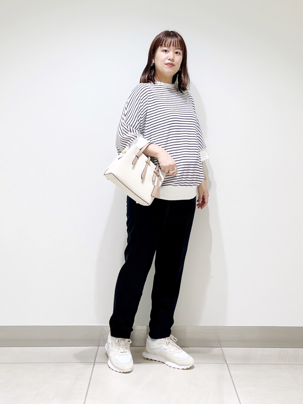 ホワイト系のTシャツ/カットソー、ブルー系のパンツ、ホワイト系のハンドバッグを着用したレディースの秋コーディネートの10枚目の写真