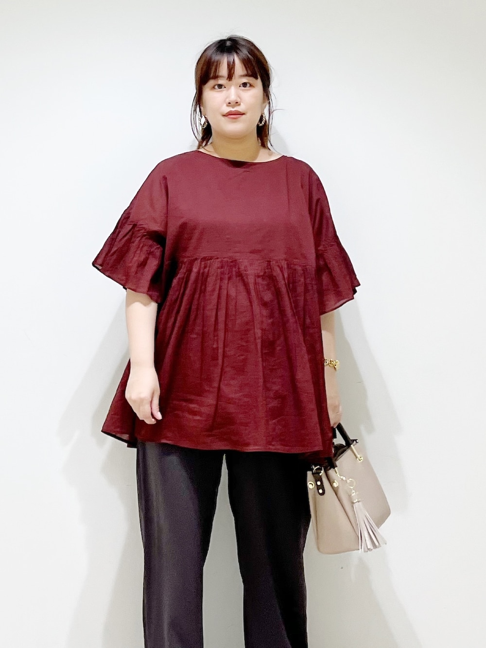 レッド系のシャツ/ブラウス、グレー系のその他パンツ、ベージュ系のトートバッグを着用したレディースの夏コーディネートの7枚目の写真