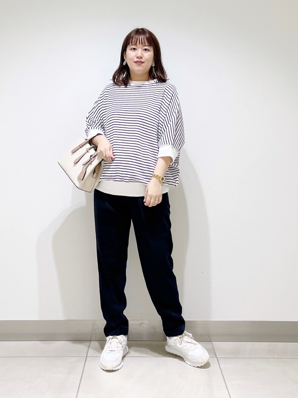 ホワイト系のTシャツ/カットソー、ブルー系のパンツ、ホワイト系のハンドバッグを着用したレディースの秋コーディネートの8枚目の写真