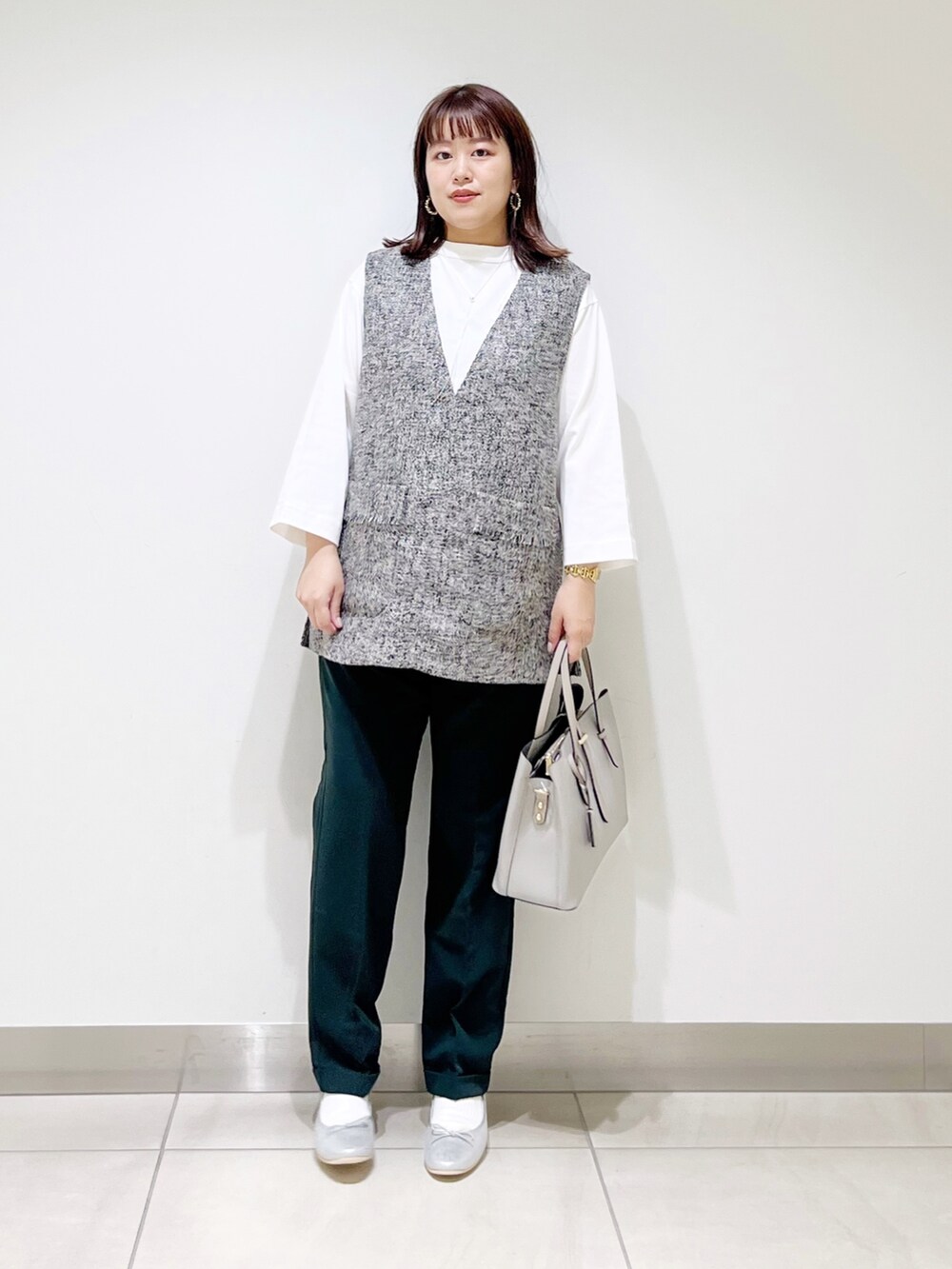 グレー系のトップス、グリーン系のパンツ、グレー系のトートバッグを着用したレディースの夏コーディネートの7枚目の写真