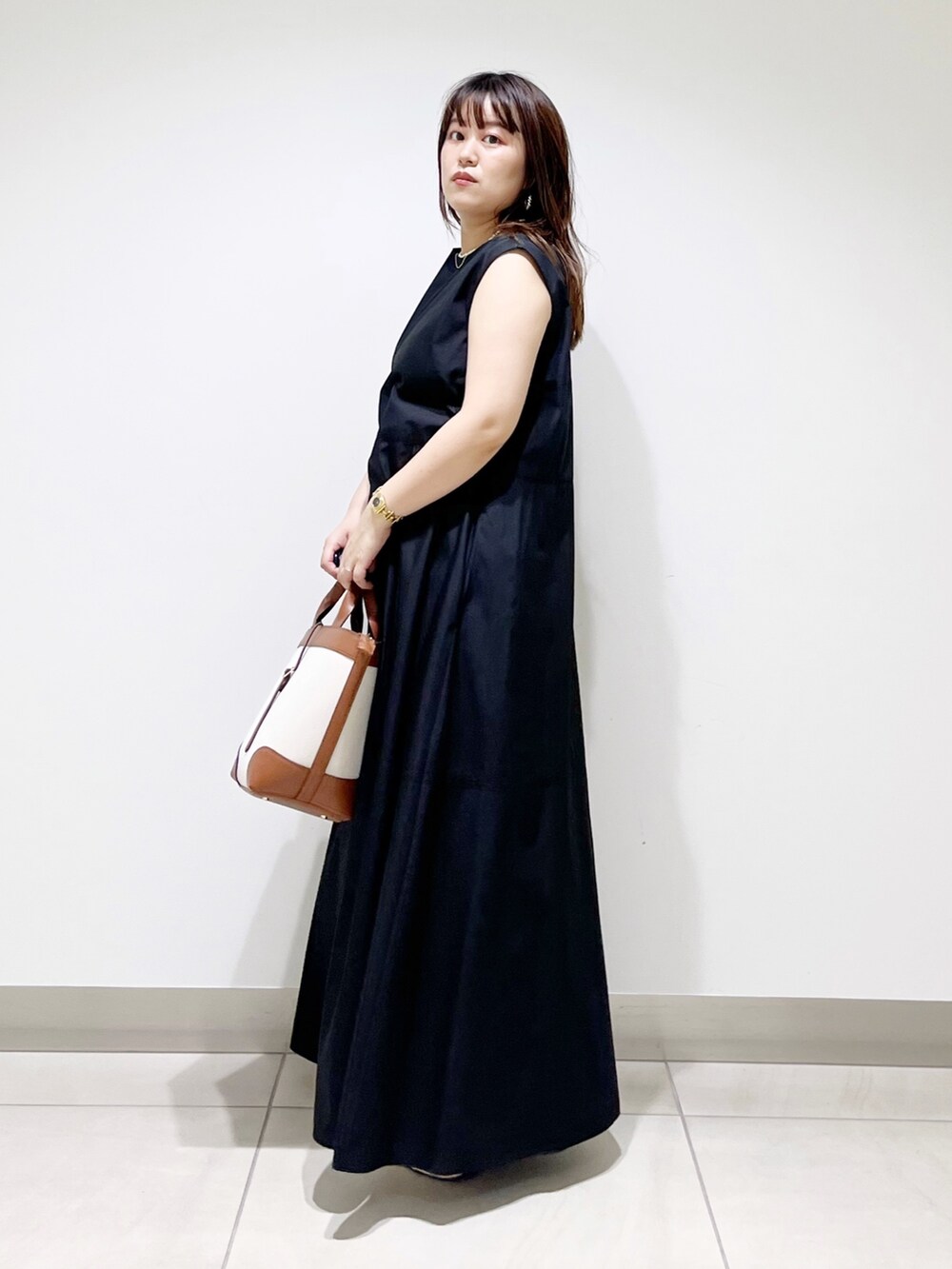 ブラック系のワンピース/ドレス、イエロー系のトートバッグ、グレー系のスニーカーを着用したレディースの夏コーディネートの5枚目の写真