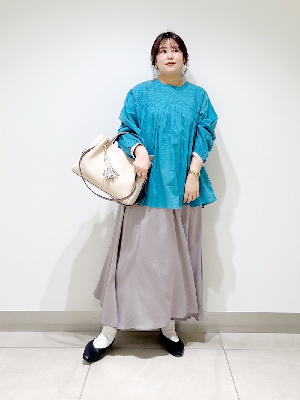 ブルー系のシャツ/ブラウス、グレー系のスカート、ホワイト系のトートバッグを着用したレディースの春コーディネートの4枚目の写真