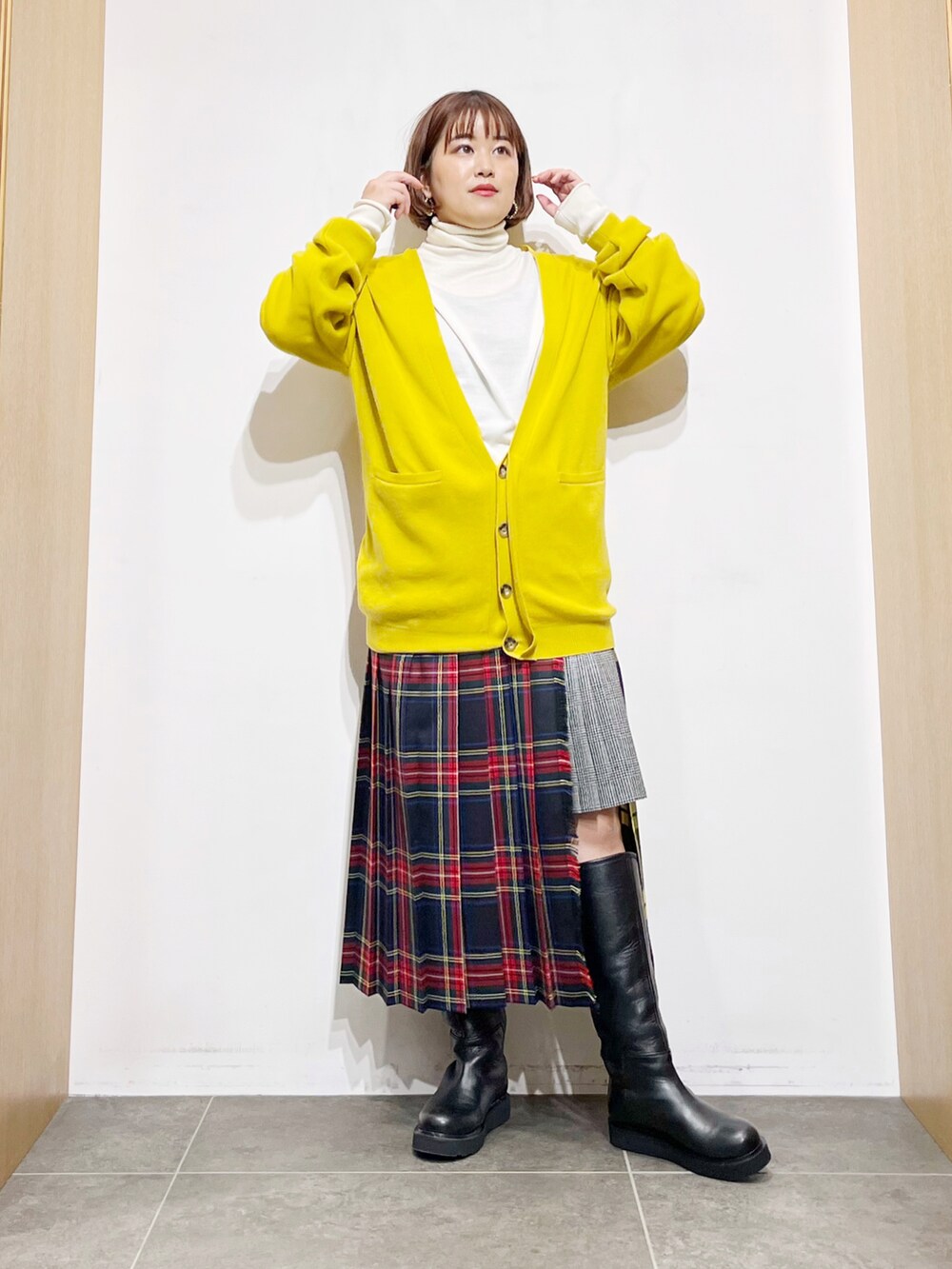 イエロー系のカーディガン/ボレロ、ホワイト系のニット/セーター、その他のスカートを着用したレディースの冬コーディネートの2枚目の写真