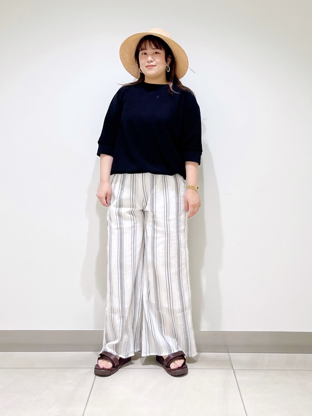 ブラック系のTシャツ/カットソー、ホワイト系のその他パンツ、ブラウン系のサンダルを着用したレディースの春コーディネートの2枚目の写真