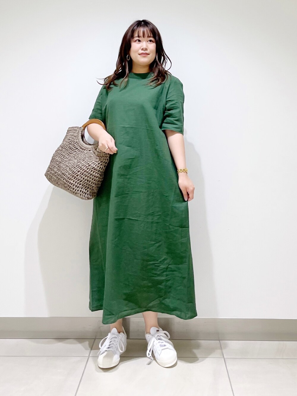 グリーン系のワンピース、グレー系のかごバッグ、ホワイト系のスニーカーを着用したレディースの夏コーディネートの10枚目の写真