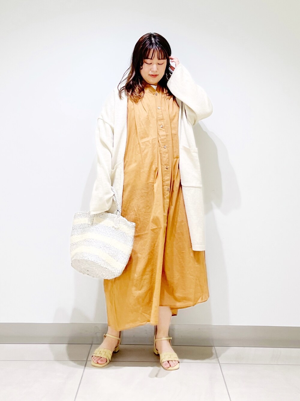 ブラウン系のワンピース、ホワイト系のカーディガン/ボレロ、ホワイト系のハンドバッグを着用したレディースの春コーディネートの6枚目の写真