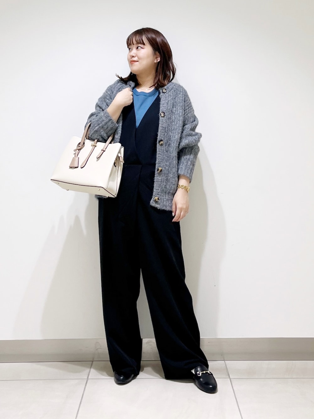 ブルー系のニット/セーター、グレー系のカーディガン/ボレロ、ブラック系のサロペット/オーバーオールを着用したレディースの秋コーディネートの6枚目の写真