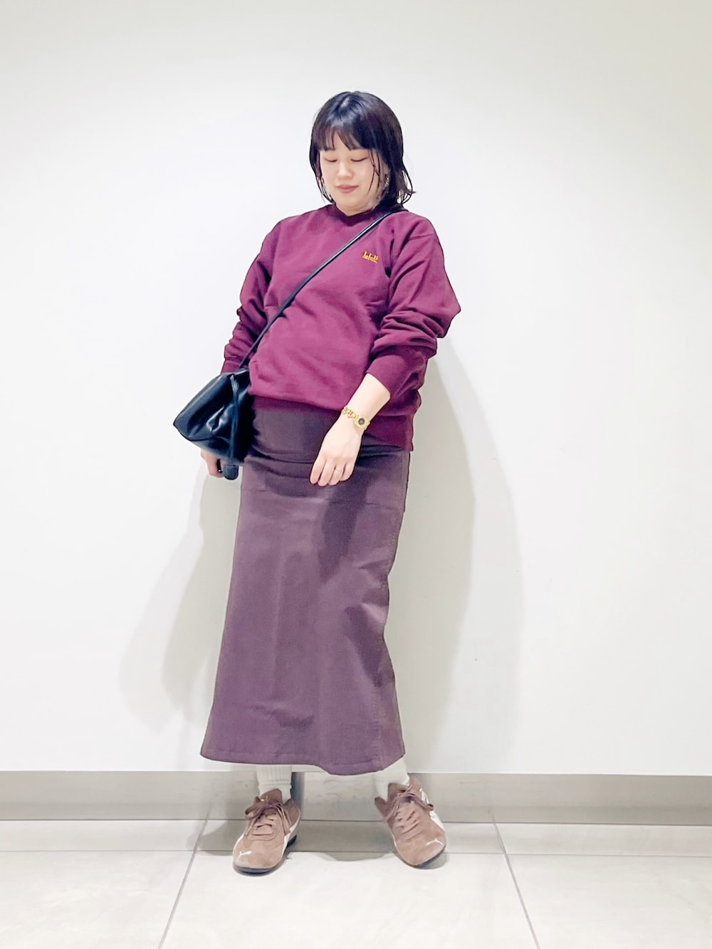 ブラウン系のスウェット、ブラウン系のスカート、ブラック系のスニーカーを着用したレディースの秋コーディネートの3枚目の写真