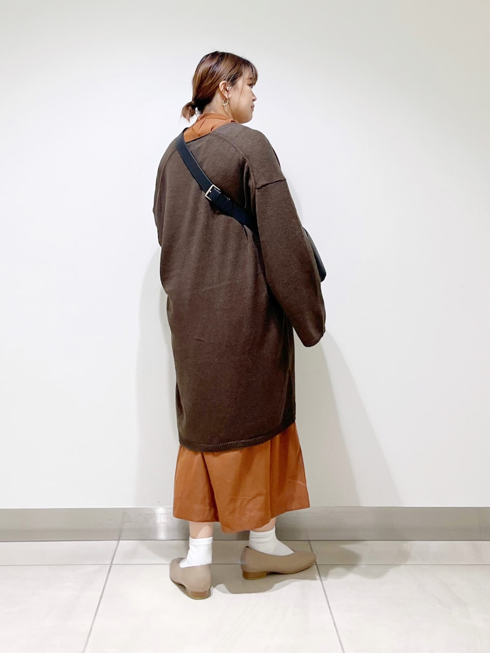 ブラウン系のカーディガン/ボレロ、イエロー系のワンピース、ブラック系のショルダーバッグを着用したレディースの秋コーディネートの4枚目の写真