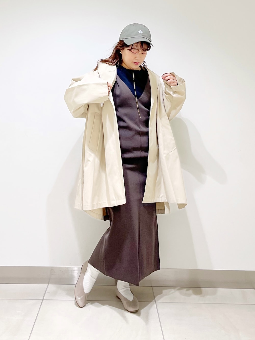 ベージュ系のポンチョ、ブラウン系のワンピース、ベージュ系のパンプスを着用したレディースの春コーディネートの3枚目の写真