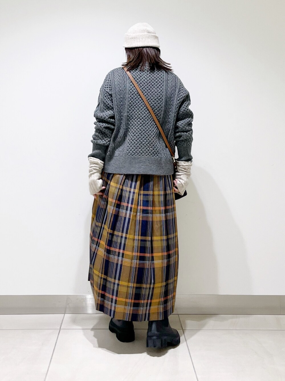 グレー系のカーディガン/ボレロ、ブルー系のスカート、ブラック系のショルダーバッグを着用したレディースの冬コーディネートの5枚目の写真