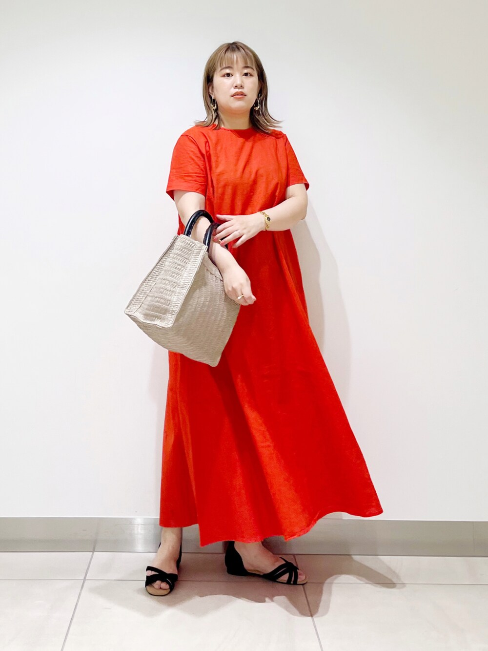 レッド系のワンピース、ベージュ系のトートバッグ、ブラック系のサンダルを着用したレディースの夏コーディネートの4枚目の写真