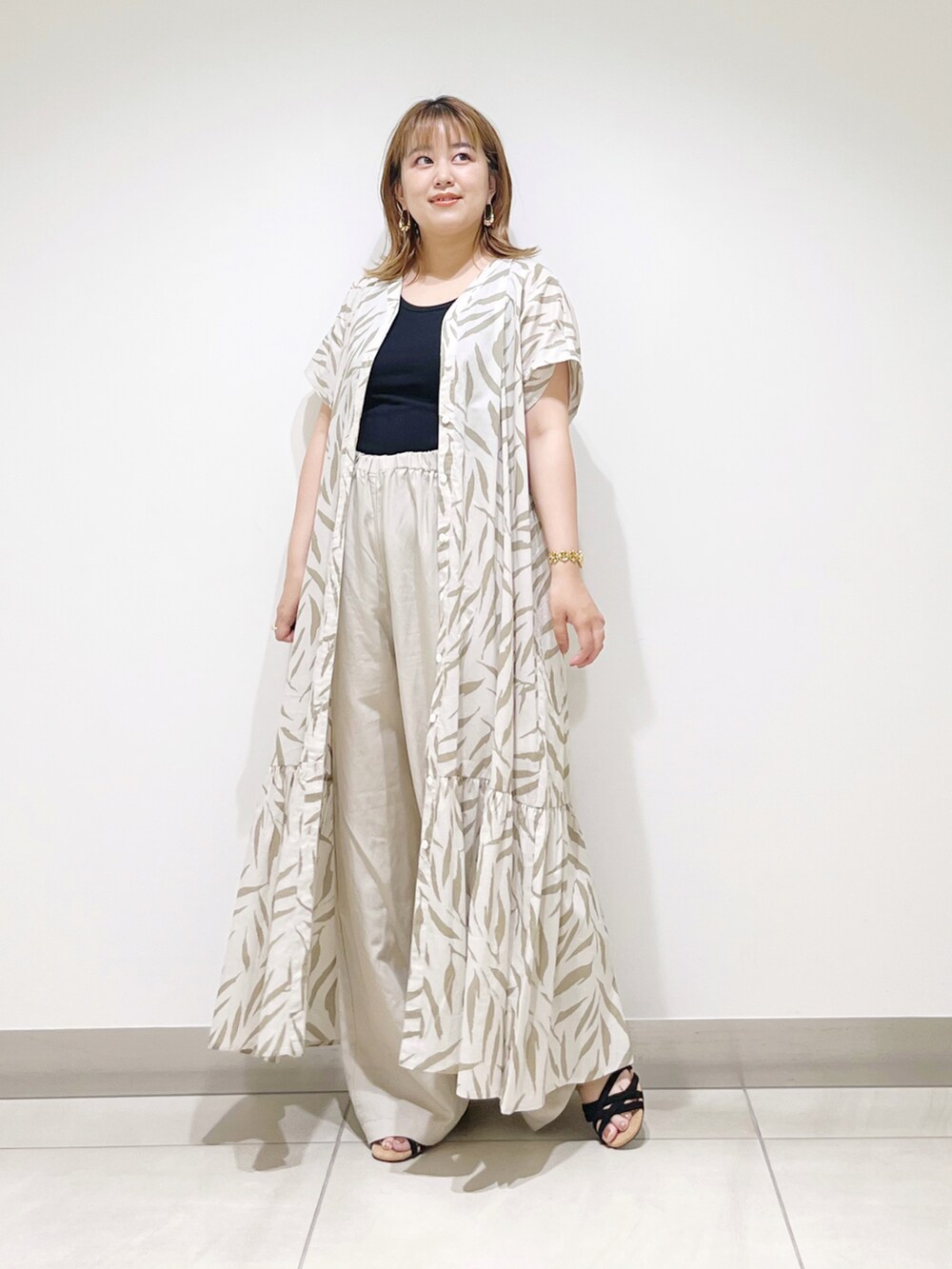 ベージュ系のワンピース、ベージュ系のその他パンツ、ブラック系のサンダルを着用したレディースの夏コーディネートの5枚目の写真