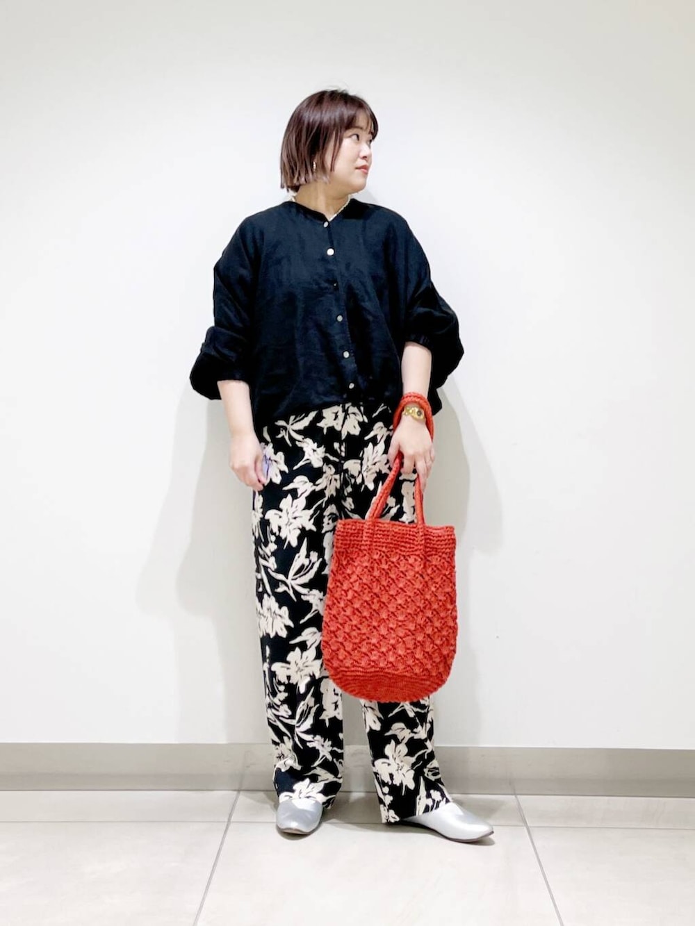 シルバー系のパンプス、ブラック系のその他パンツ、オレンジ系のトートバッグを着用したレディースの春コーディネートの7枚目の写真