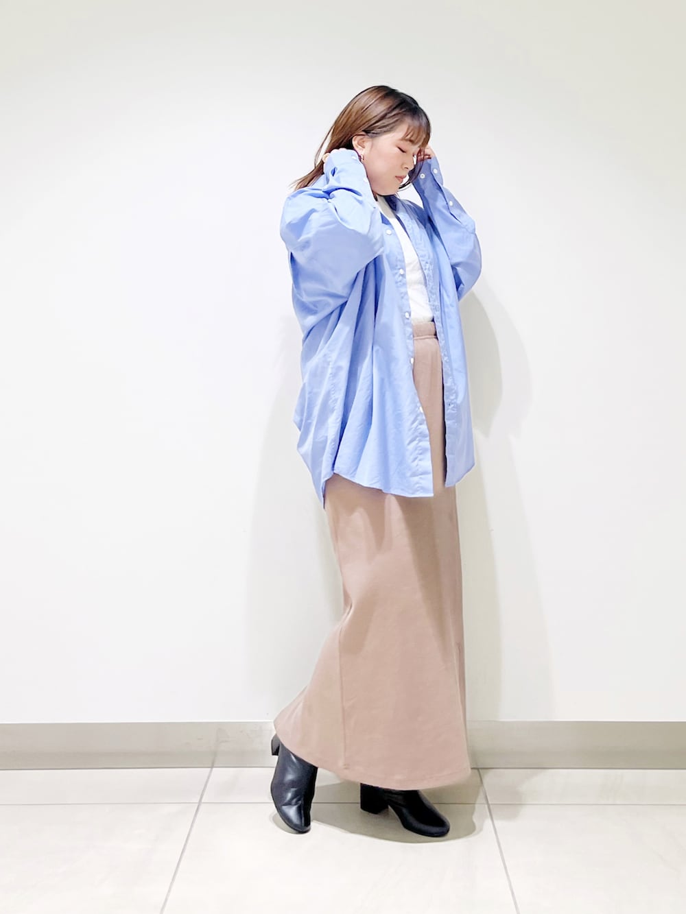 ブルー系のシャツ/ブラウス、ベージュ系のスカート、ブラック系のブーツを着用したレディースの秋コーディネートの4枚目の写真