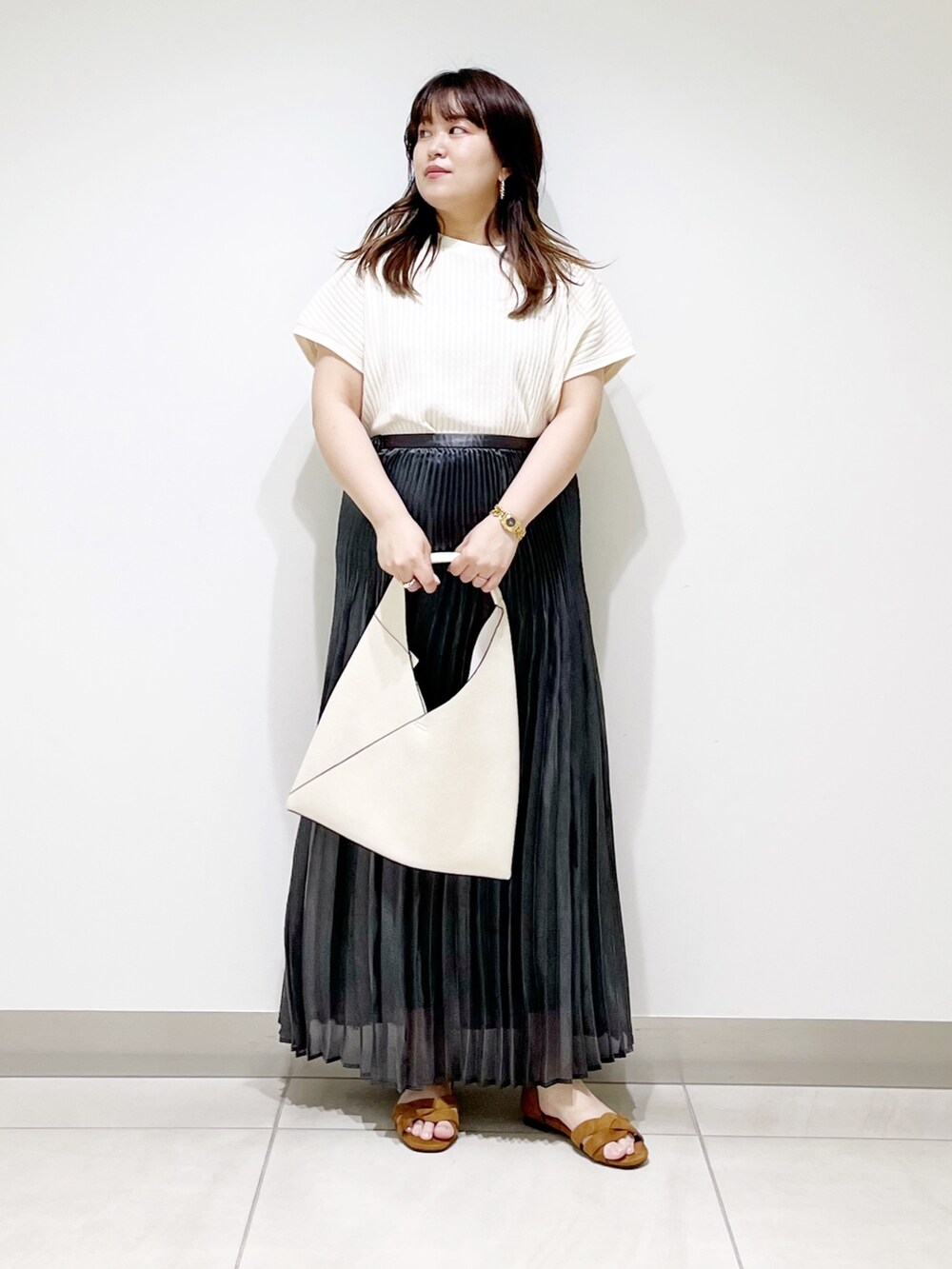 ブラック系のスカート、ホワイト系のニット/セーター、ホワイト系のトートバッグを着用したレディースの夏コーディネートの9枚目の写真
