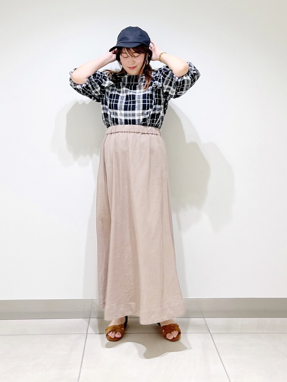 ベージュ系のスカート、ベージュ系のサンダル、ブラック系のシャツ/ブラウスを着用したレディースの夏コーディネートの8枚目の写真