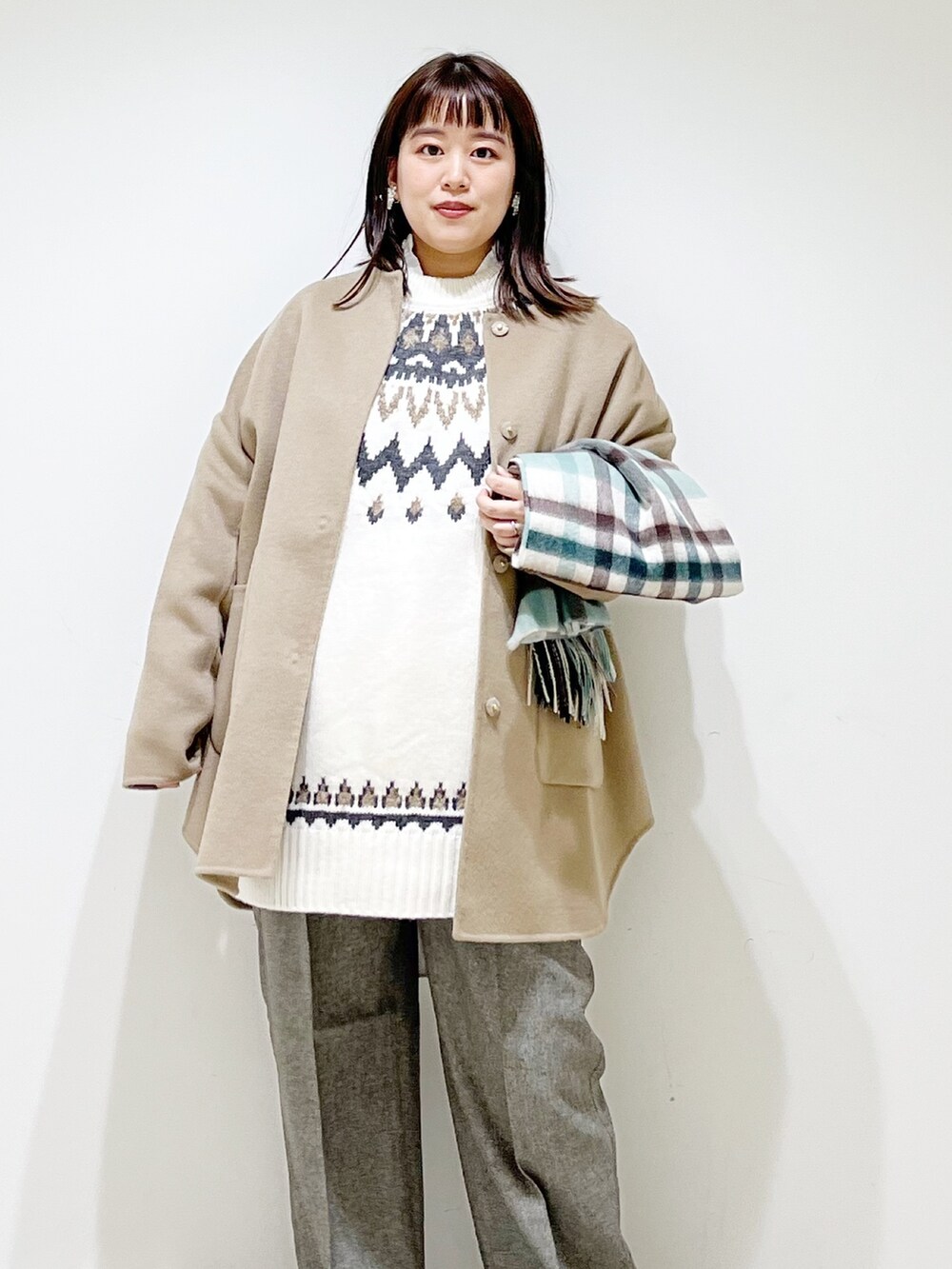 ベージュ系のノーカラージャケット、ホワイト系のニット/セーター、グレー系のその他パンツを着用したレディースの秋コーディネートの4枚目の写真