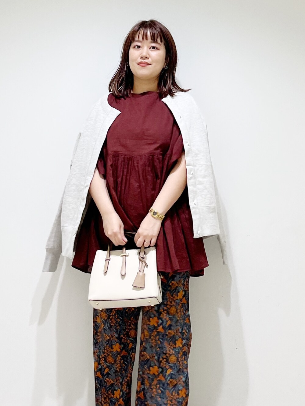 オレンジ系のその他パンツ、レッド系のシャツ/ブラウス、グレー系のカーディガン/ボレロを着用したレディースの秋コーディネートの7枚目の写真