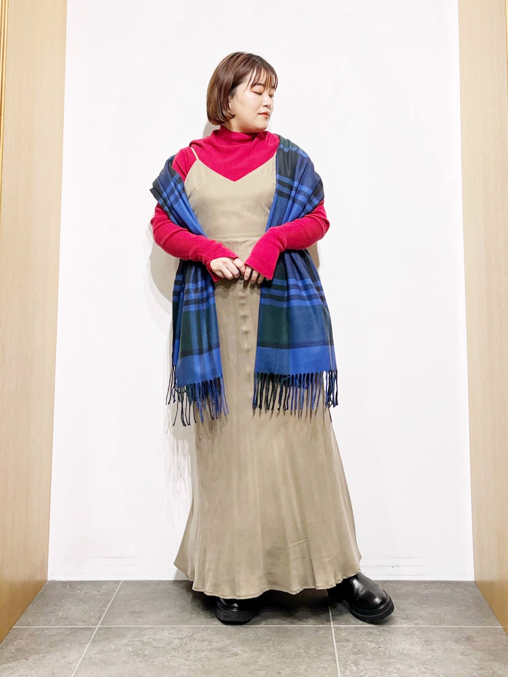 ベージュ系のワンピース、ブラック系のブーツ、レッド系のニット/セーターを着用したレディースの冬コーディネートの4枚目の写真