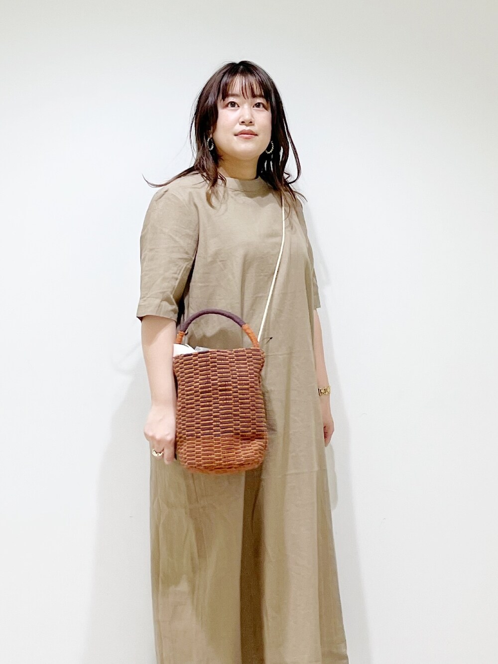 ベージュ系のワンピース、ブラウン系のショルダーバッグ、ブラック系のサンダルを着用したレディースの春コーディネートの4枚目の写真