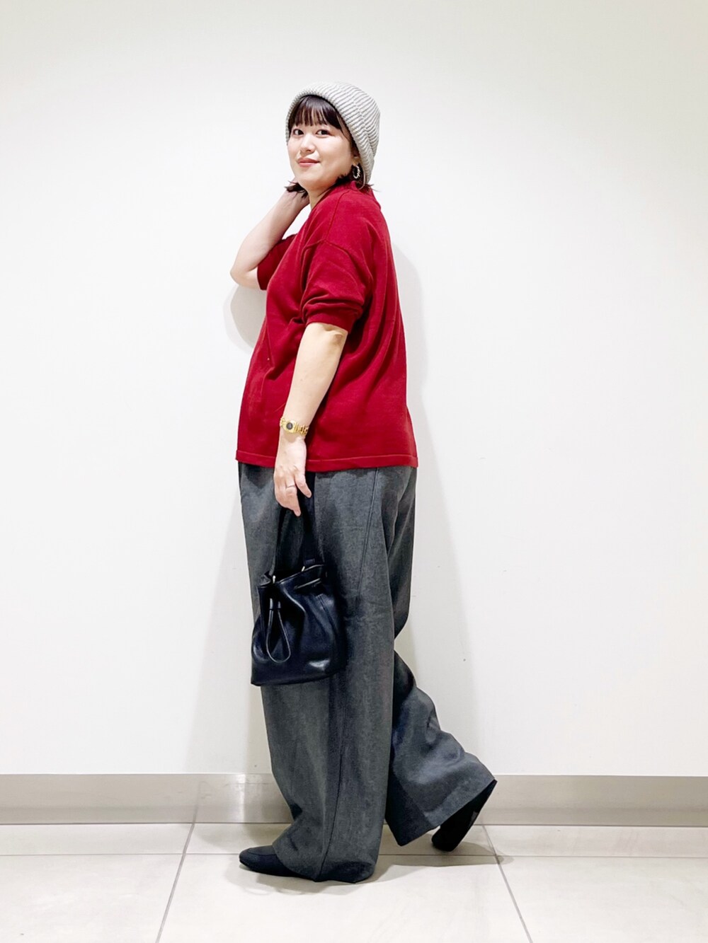 レッド系のニット/セーター、ブラック系のショルダーバッグ、グレー系のその他パンツを着用したレディースの秋コーディネートの5枚目の写真