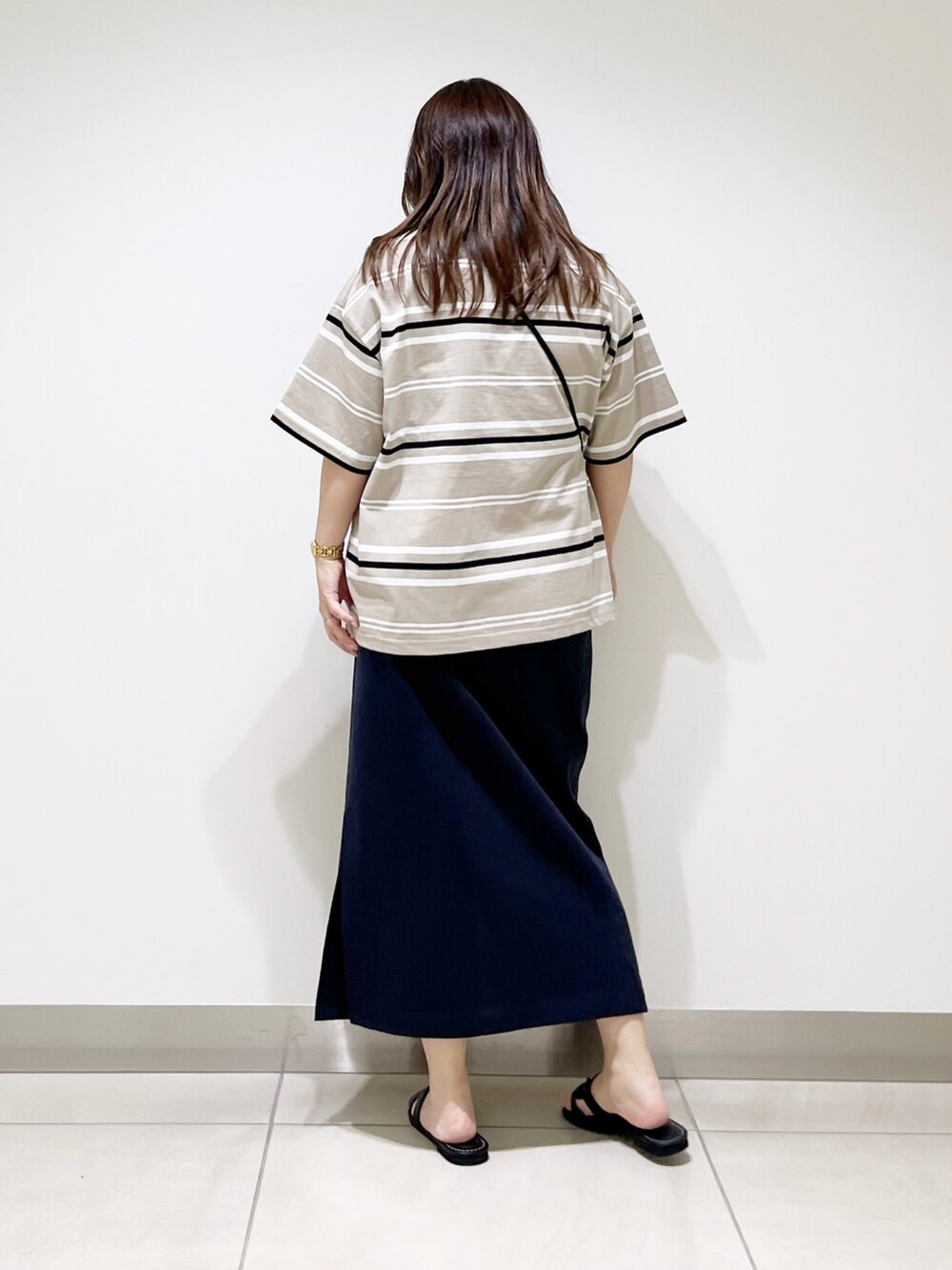 ベージュ系のTシャツ/カットソー、ブルー系のスカート、ブラック系のショルダーバッグを着用したレディースの夏コーディネートの4枚目の写真