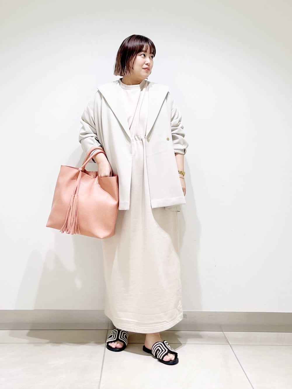 ピンク系のトートバッグ、ベージュ系のその他アウター、ベージュ系のワンピースを着用したレディースの春コーディネートの7枚目の写真