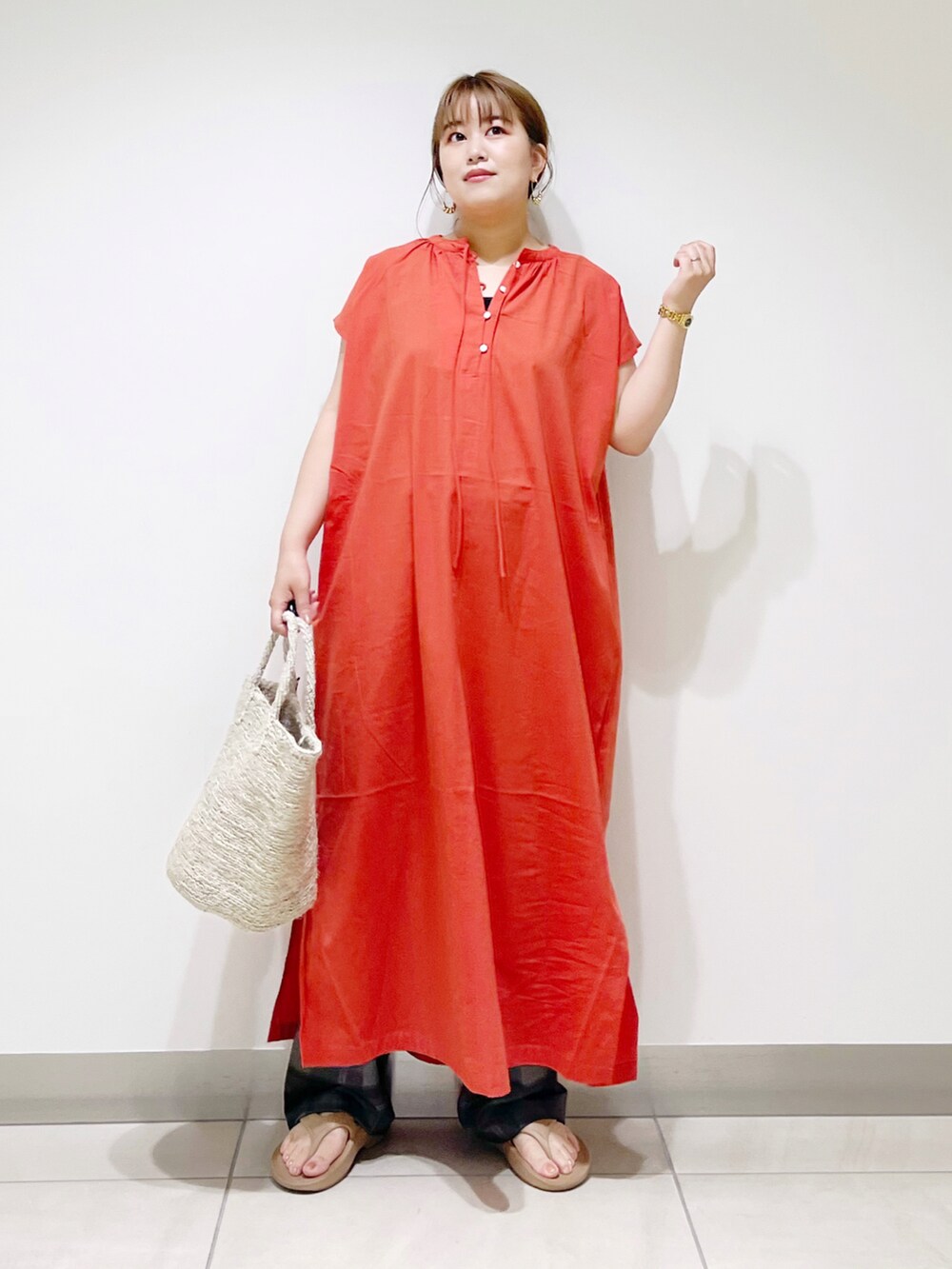 オレンジ系のワンピース、グレー系のトートバッグ、ベージュ系のサンダルを着用したレディースの春コーディネートの5枚目の写真