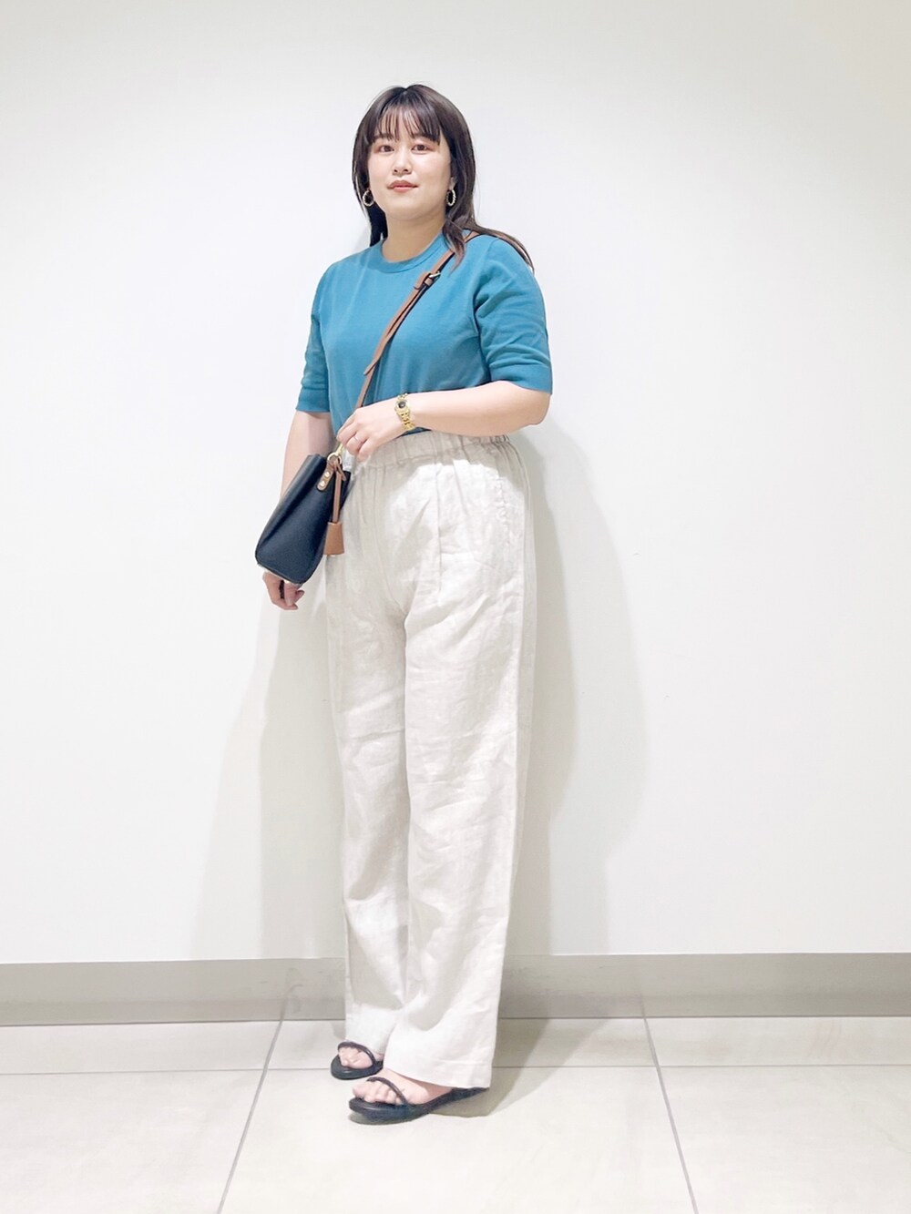 ブルー系のニット/セーター、ベージュ系のその他パンツ、ブラック系のショルダーバッグを着用したレディースの春コーディネートの5枚目の写真