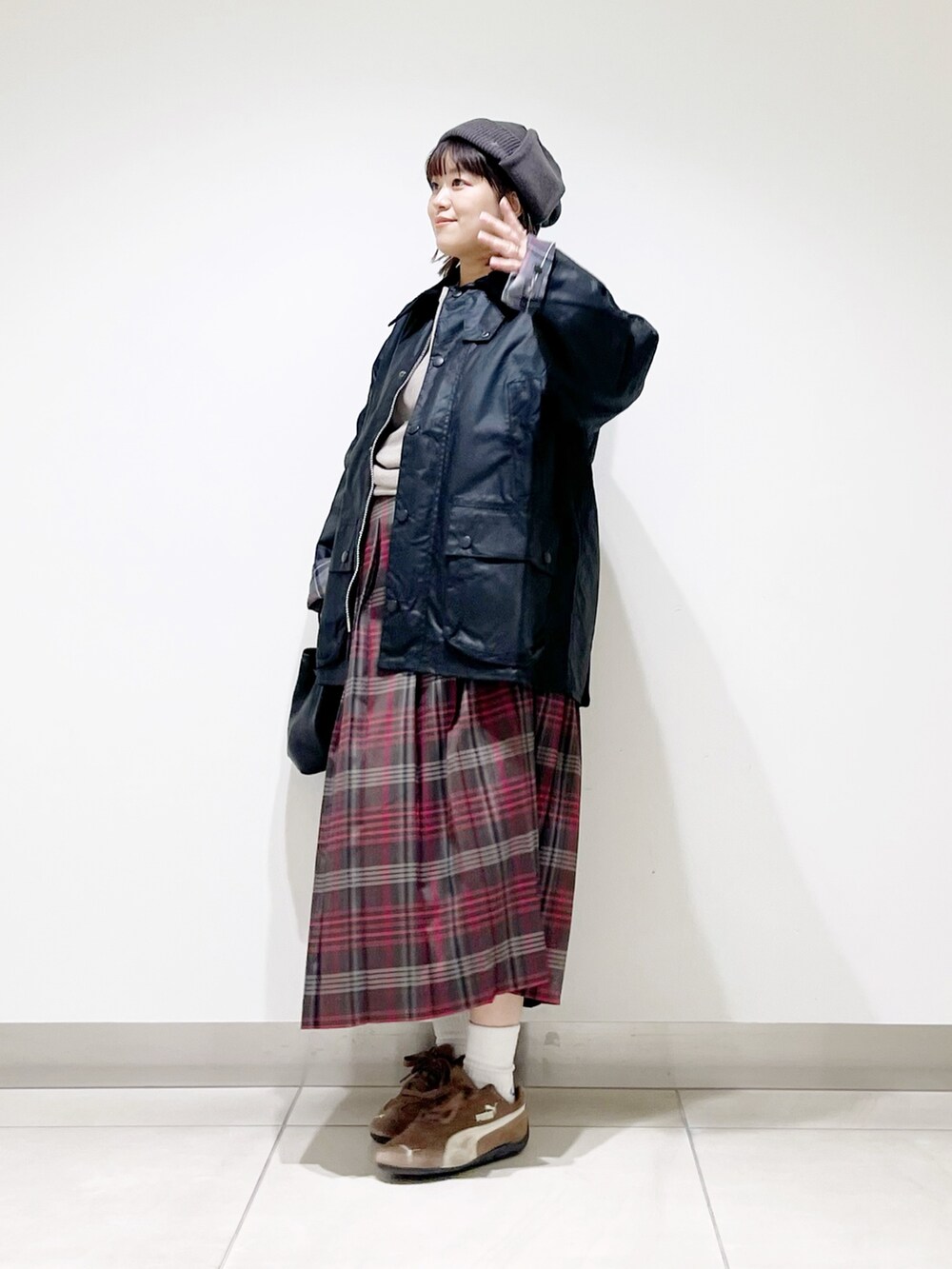 ブラック系のテーラードジャケット、グレー系のTシャツ/カットソー、ブラウン系のスカートを着用したレディースの秋コーディネートの9枚目の写真