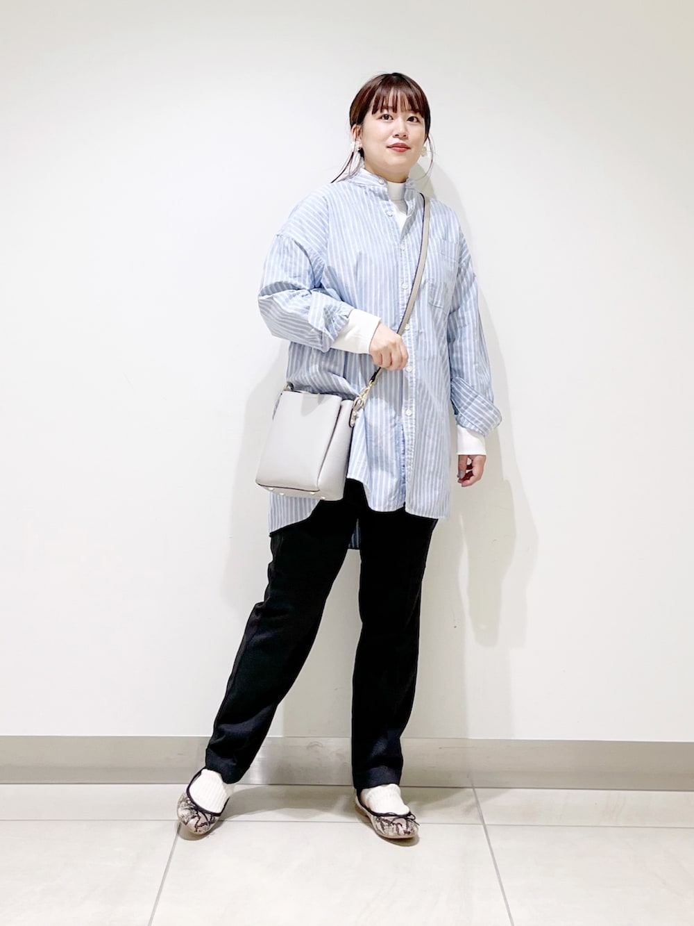 ホワイト系のTシャツ/カットソー、ブルー系のシャツ/ブラウス、グレー系のショルダーバッグを着用したレディースの秋コーディネートの2枚目の写真