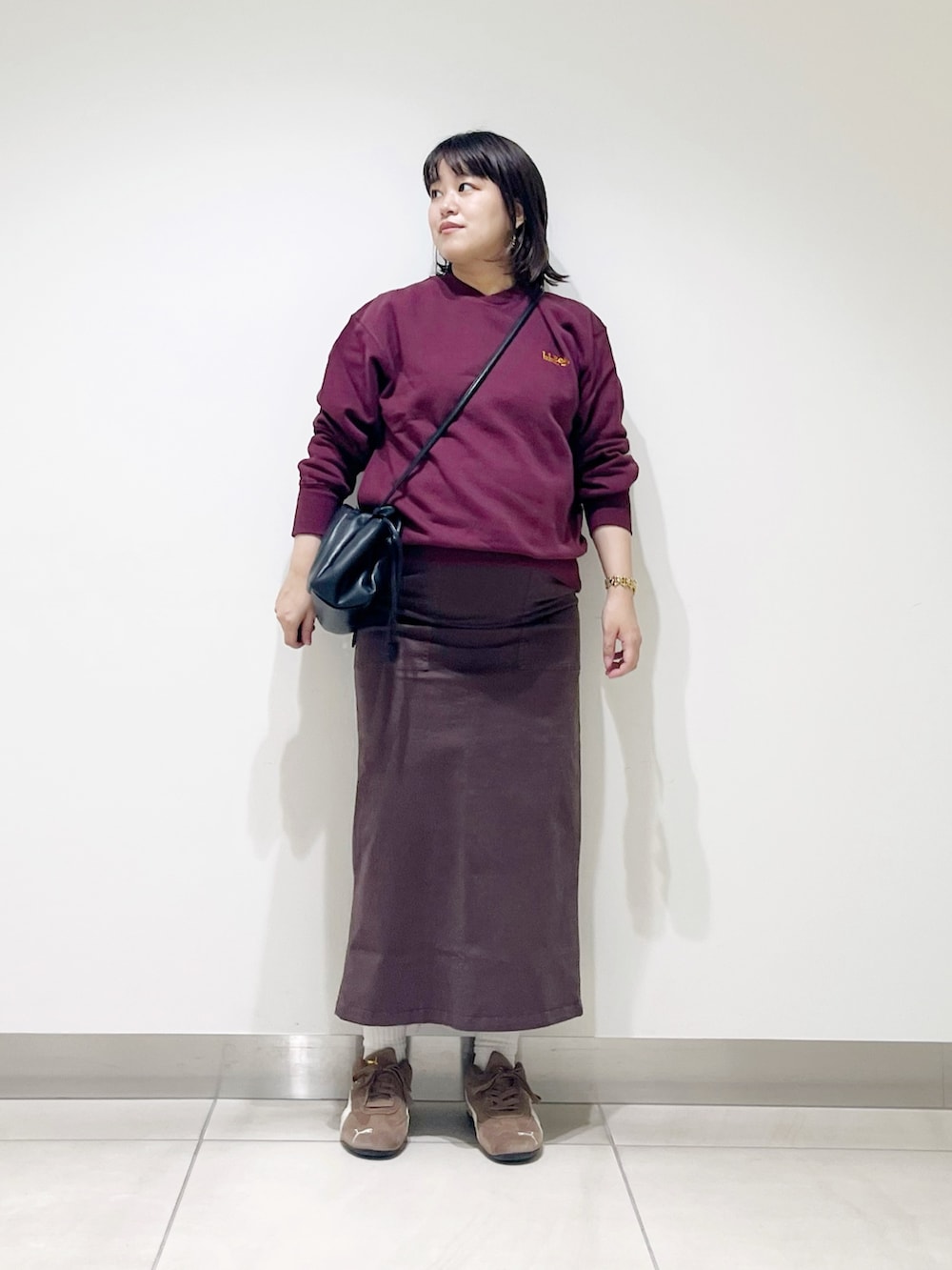 ブラウン系のスウェット、ブラウン系のスカート、ブラック系のスニーカーを着用したレディースの秋コーディネートの8枚目の写真