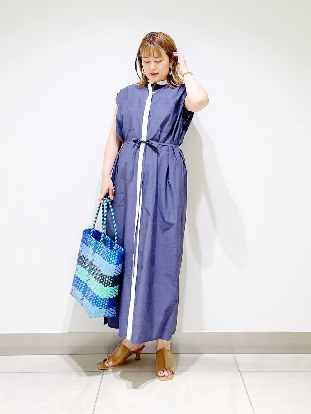 ブルー系のワンピース、ブルー系のトートバッグ、ベージュ系のサンダルを着用したレディースの夏コーディネートの5枚目の写真