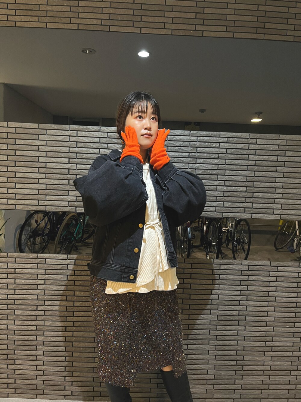 ブラック系のスカート、ブラック系のデニムジャケット、ホワイト系のTシャツ/カットソーを着用したレディースの秋コーディネートの4枚目の写真