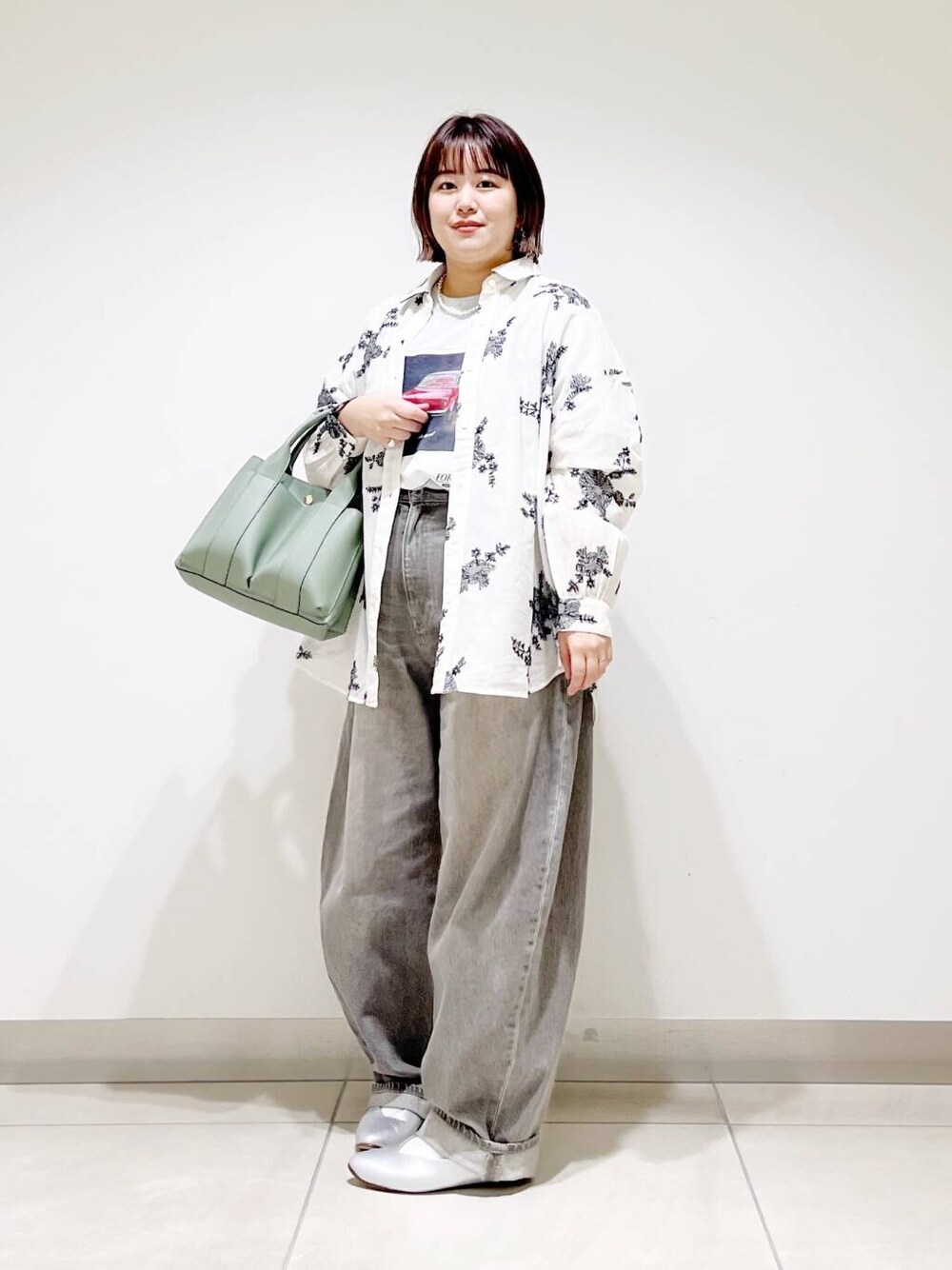 グリーン系のデニムパンツ、グリーン系のトートバッグ、シルバー系のパンプスを着用したレディースの春コーディネートの5枚目の写真