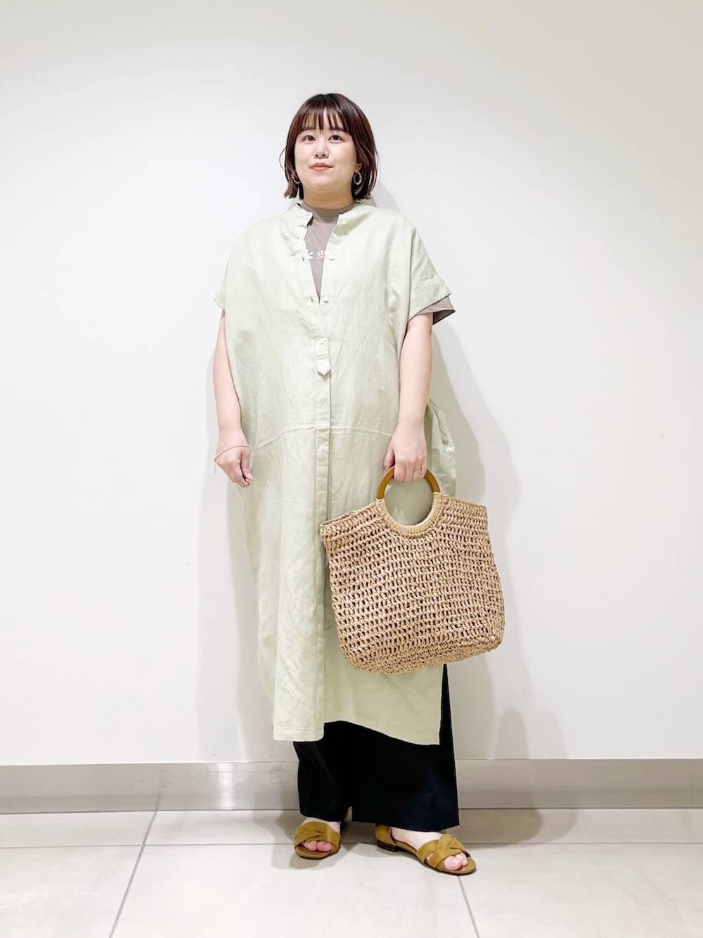 ブラック系のその他パンツ、グリーン系のワンピース、ベージュ系のトートバッグを着用したレディースの春コーディネートの6枚目の写真