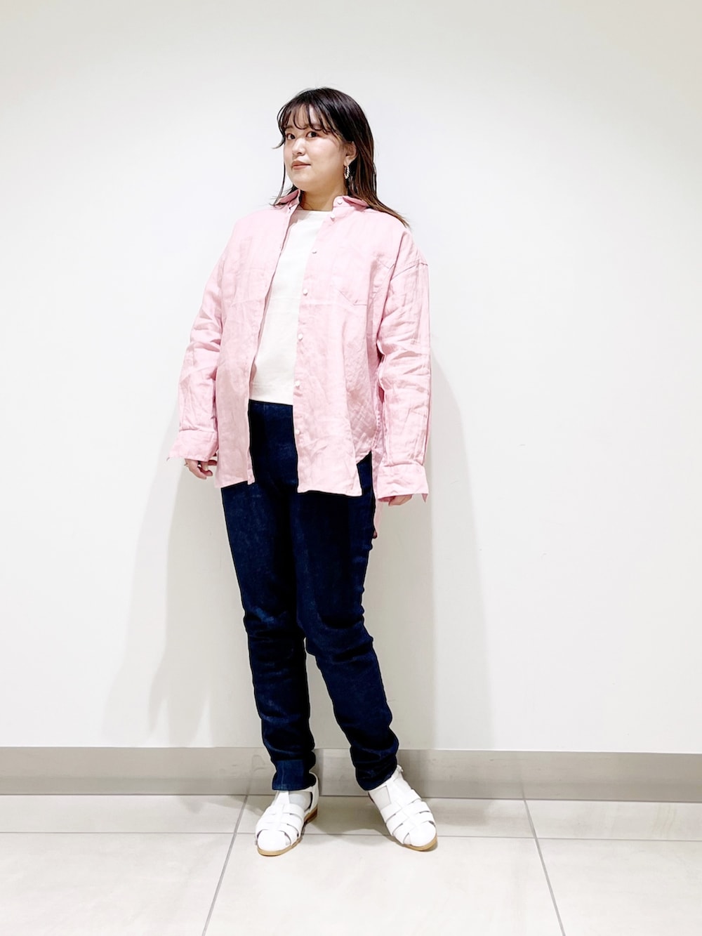 ピンク系のシャツ/ブラウス、ベージュ系のTシャツ/カットソー、ブルー系のデニムパンツを着用したレディースの春コーディネートの4枚目の写真