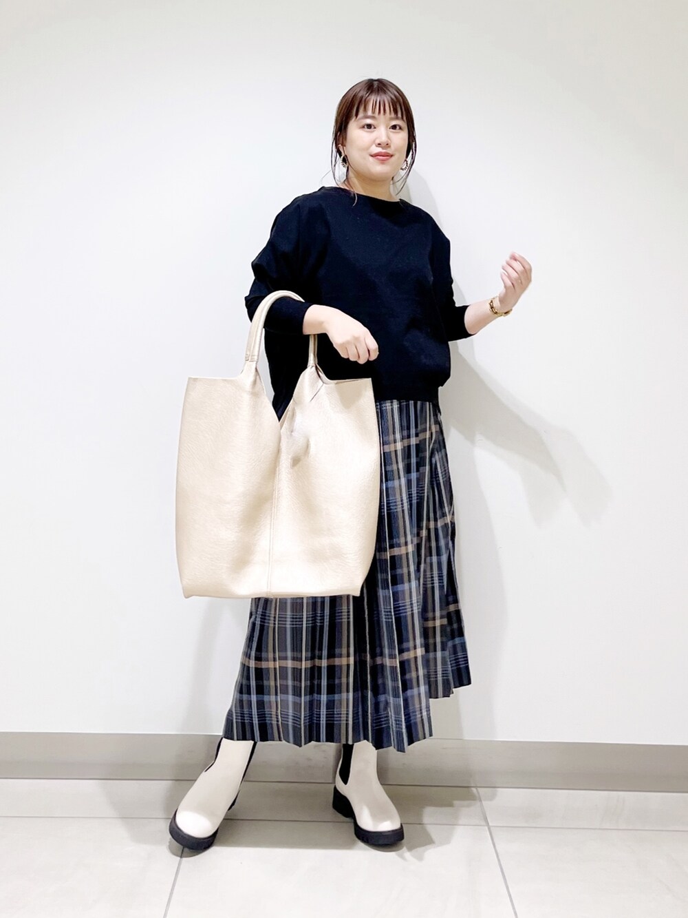 ブラック系のTシャツ/カットソー、ゴールド系のトートバッグ、ホワイト系のブーツを着用したレディースの秋コーディネートの5枚目の写真
