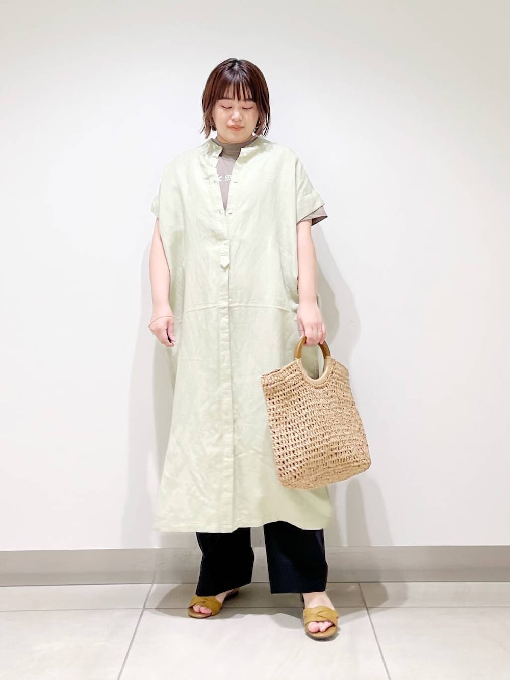 ブラック系のその他パンツ、グリーン系のワンピース、ベージュ系のトートバッグを着用したレディースの春コーディネートの9枚目の写真